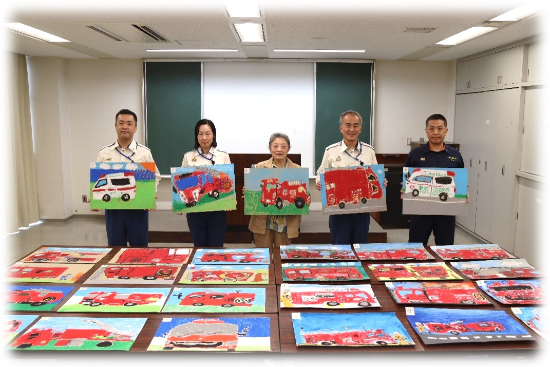 こどもたちの作品を手に集合写真