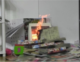 地震で本がストーブの上に落下している様子