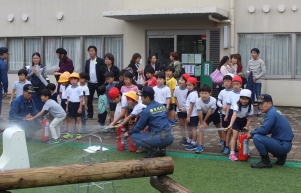 小学校で、子どもたちと模擬消火器で消火訓練